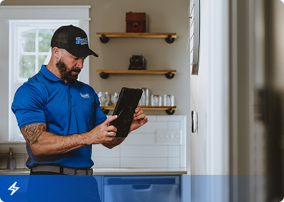 Electrical CTA Bassett Services electrician reviewing a tablet in a home kitchen