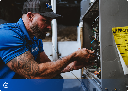 Bassett-Heating-CTA Bassett Services technician repairing the wiring inside a furnace