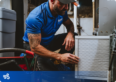 Bassett-IAQ-CTA Bassett Services technician replacing a furnace air filter